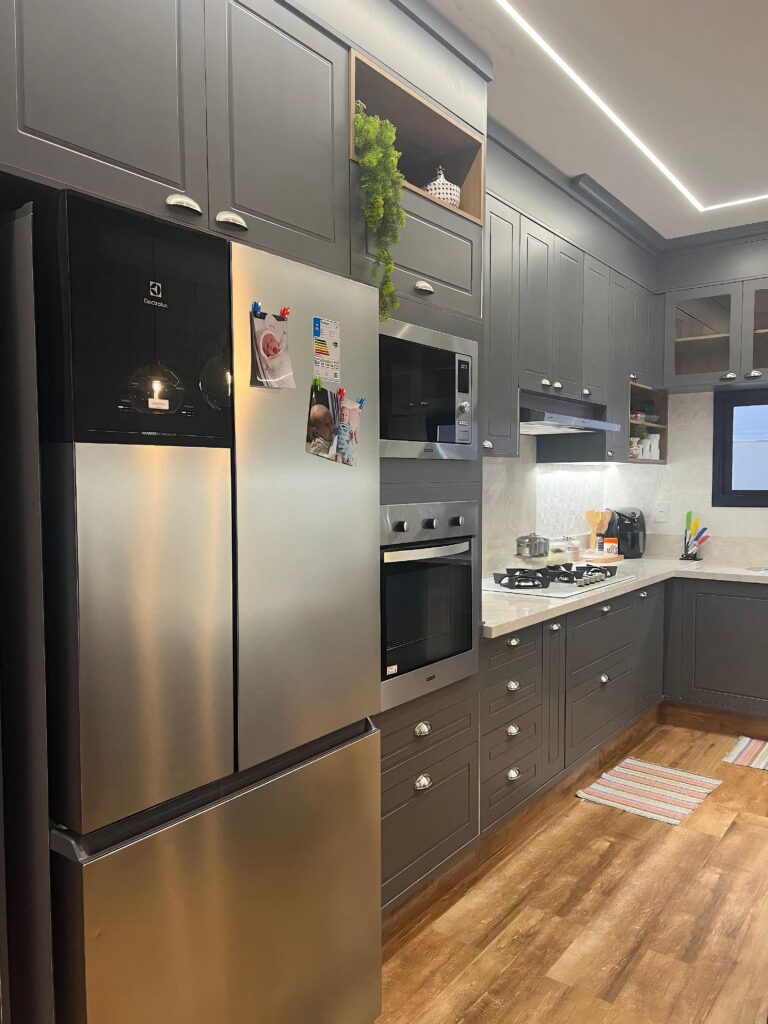 Cozinha planejada em L com torre quente, cooktop e armários até o teto, projeto Kless Sertãozinho